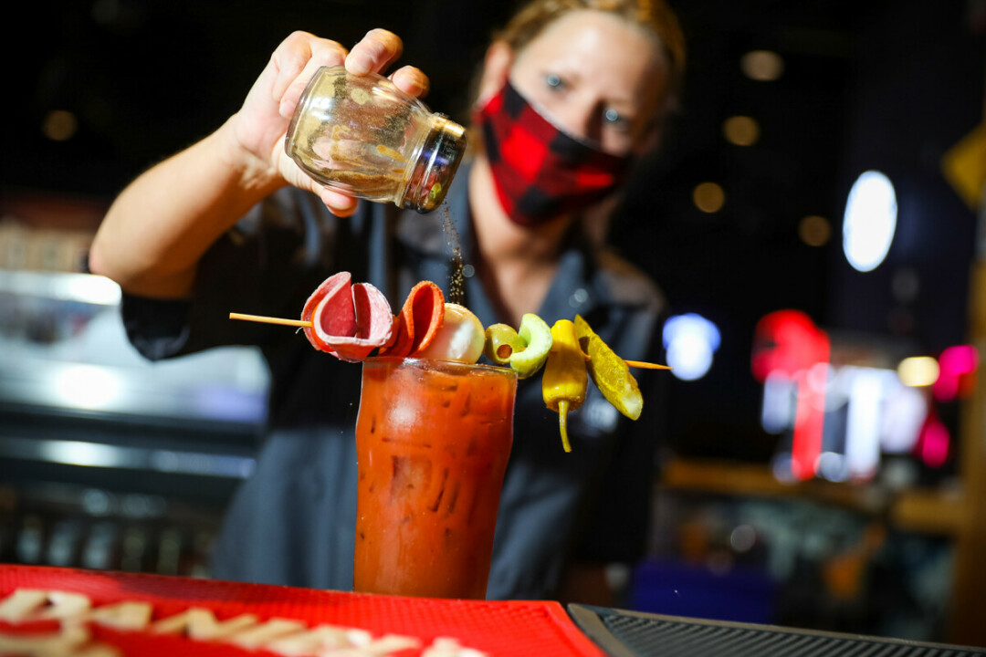 A bartender prepared a drink while wearing a face mask at Stout Craft Co. in Menomonie.