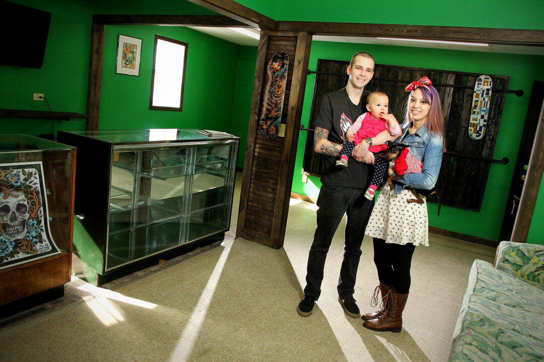 Chris Johnson, who opened Passion Board Skate Shop in 2014, posed with his daughter’s mother Kirstin, his daughter Lily, and beloved pup Madeye shortly after the shop opened in 2014. (Photo by Andrea Paulseth)