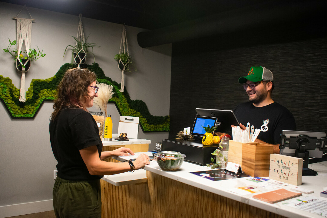 GET JUICY WITH IT. Dawson Roberts (right), mind behind the Fuel, checking out a regular at Fast Fuel. The on-the-go juice and whole food bar has been so busy, it has yet to have a grand opening despite its recent one-year anniversary in June.