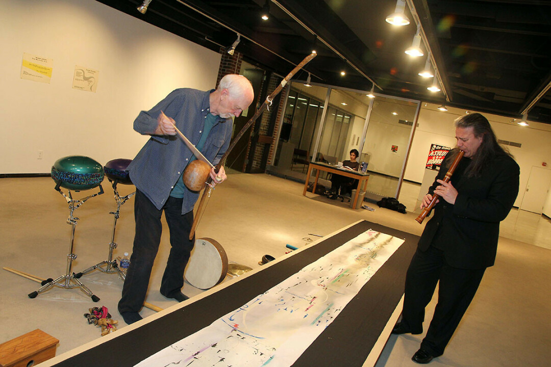 On March 6, Tiit Raid (above) and Peter Phippen played “Shading” at UWEC’s Foster Gallery – a visual/auditory piece by Australian artist Catherine Schieve. The piece combines hieroglyphics as musical score and art – various forms of music performed in traditional and experimental methods, both instrumental and vocal, to visual cues in a 40-foot two-dimensional painting.