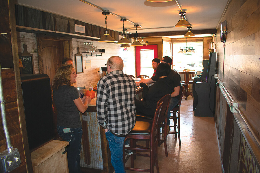 WHERE EVERYBODY KNOWS YOUR NAME. Jessica Bertoni, far left, with patrons at her new bar, The Waiting Room, on Bellinger Street.