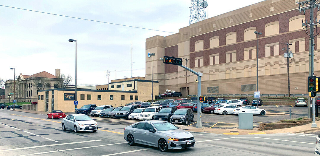 DOWNTOWN PROPOSAL. This city parking lot in the 300 block of South Farwell Street is being considered as the site for a day center for the city’s unhoused population. The building housing Offbeats Violin & Guitar Studio is at left, with City Hall at far left. 