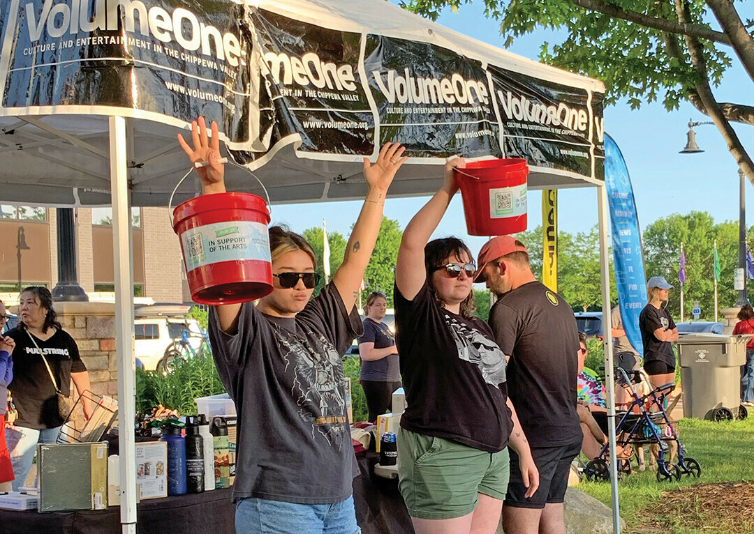 MAKING THE MUSICIANS MERRY. The writer (at right) holds aloft a red fundraising bucket at a Sounds Like Summer concert in Phoenix Park.